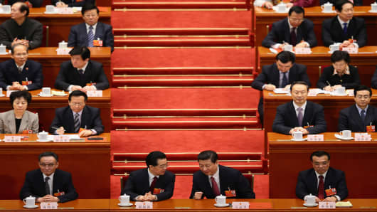 China's newly-elected President Xi Jinping (R) talks with former President Hu Jintao (L) during the fourth plenary meeting of the National People's Congress at the Great Hall of the People in Beijing.